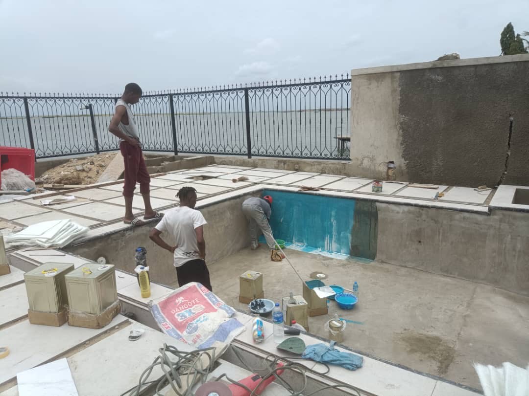 Fibreglass pool under construction with workers