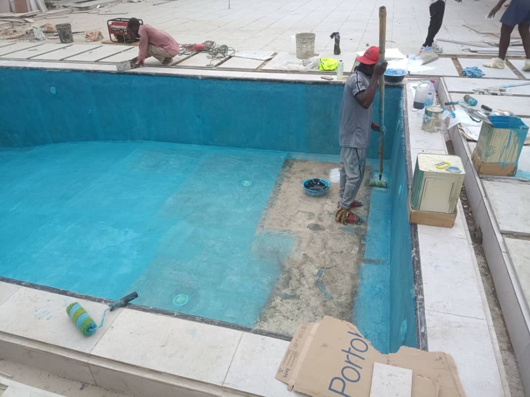 Fibreglass pool under construction with workers